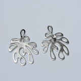 Silver coral shaped earrings on a light gray background