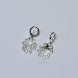 Silver coral shaped earrings with huggie hoops on a grey background