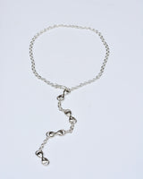 Silver chain necklace on a light gray background