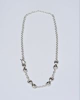Silver necklace with infinity-shaped links on a light gray background