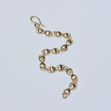 Gold chain bracelet on a light gray background