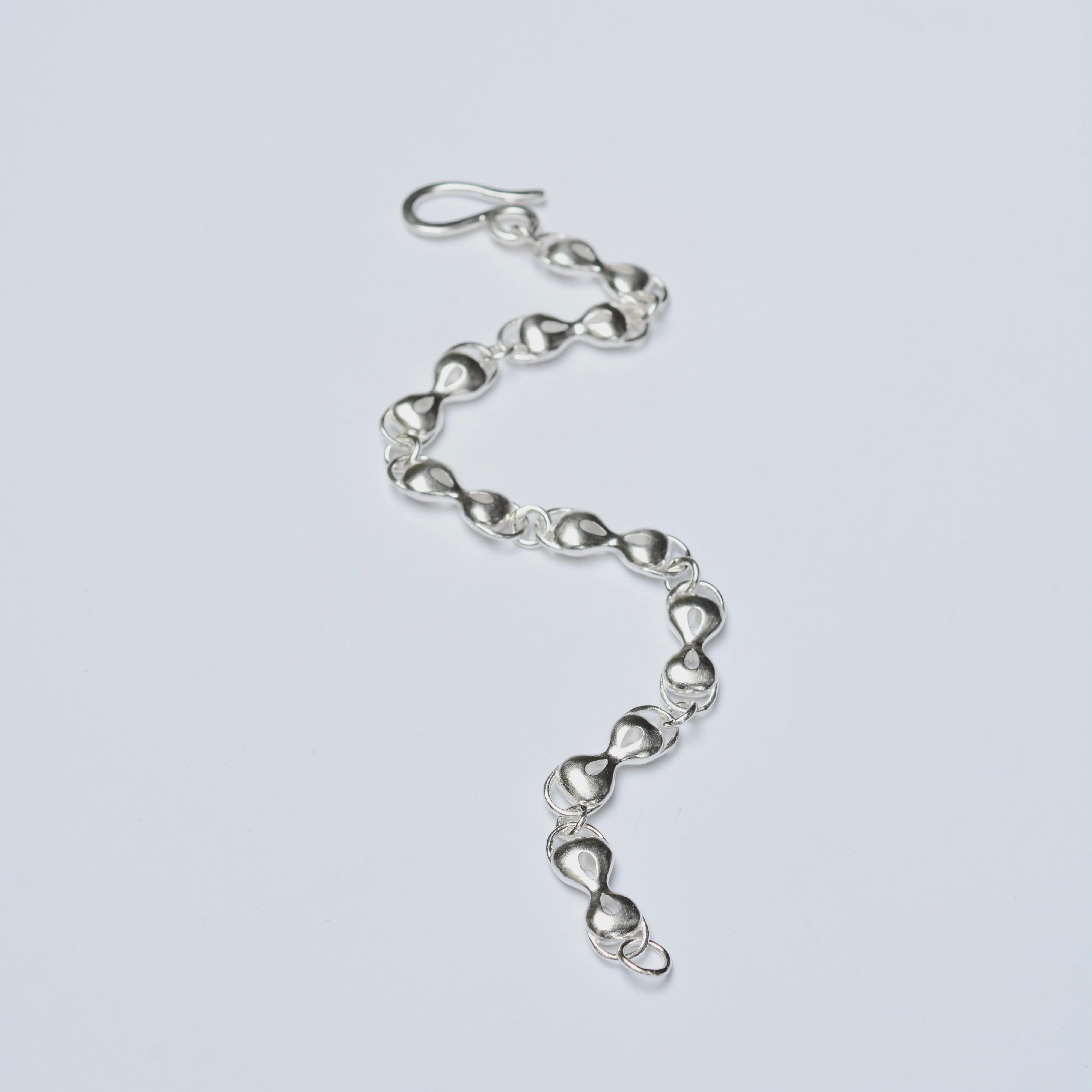 Silver chain bracelet on a light gray background
