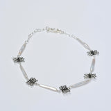 Silver necklace with coral charms on a light gray background