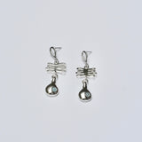 Sterling silver earrings with a plant shaped charm and droplet charm featuring light blue aquamarine stones