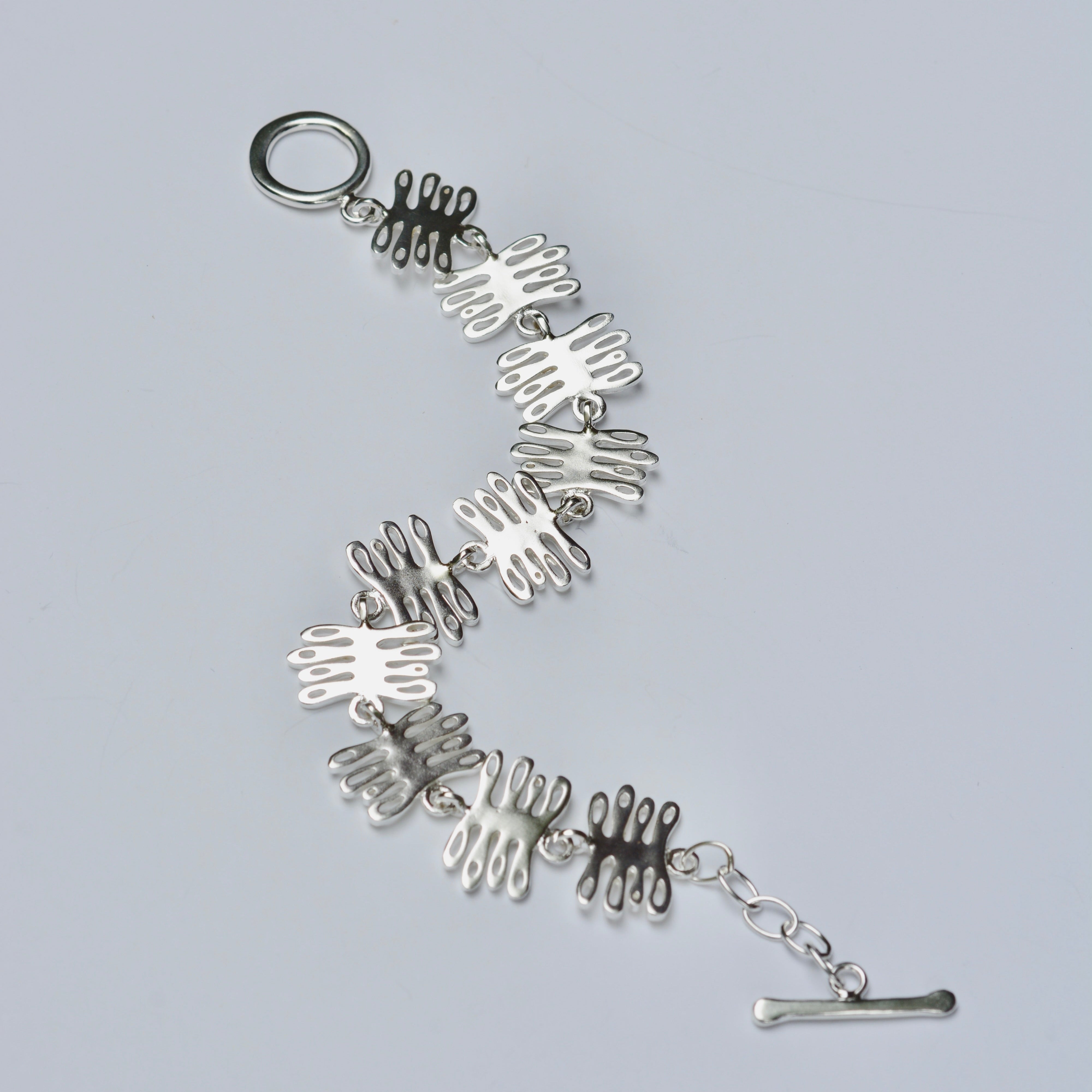 Silver bracelet with unique coral design on a light gray background