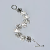 Silver bracelet with unique coral design on a light gray background