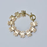 Bronze bracelet with coral-shaped charms on a light gray background