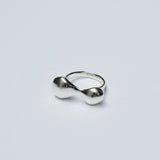 Silver organic shaped ring on a light gray background