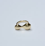 Bronze organic blobby ring on a light gray background