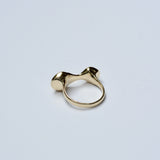 Back view of a bronze ring with an organic shape on a grey background