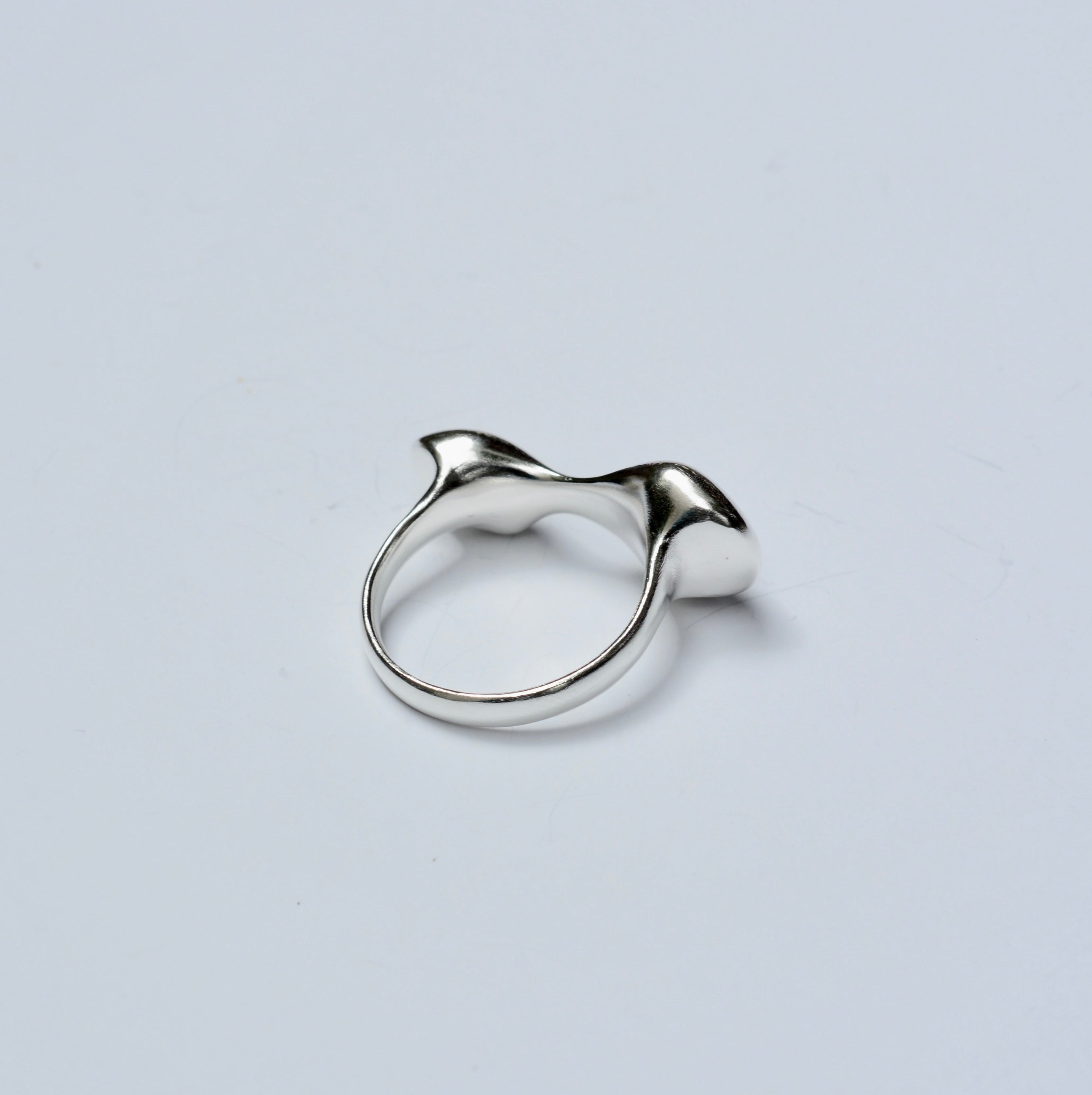 Sterling silver organic shaped ring on a grey background