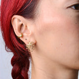 Close-up of a person wearing bronze wavy ear cuff and coral shaped bronze earring. 