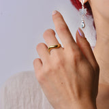 Hand wearing a bronze ring with a blurred background