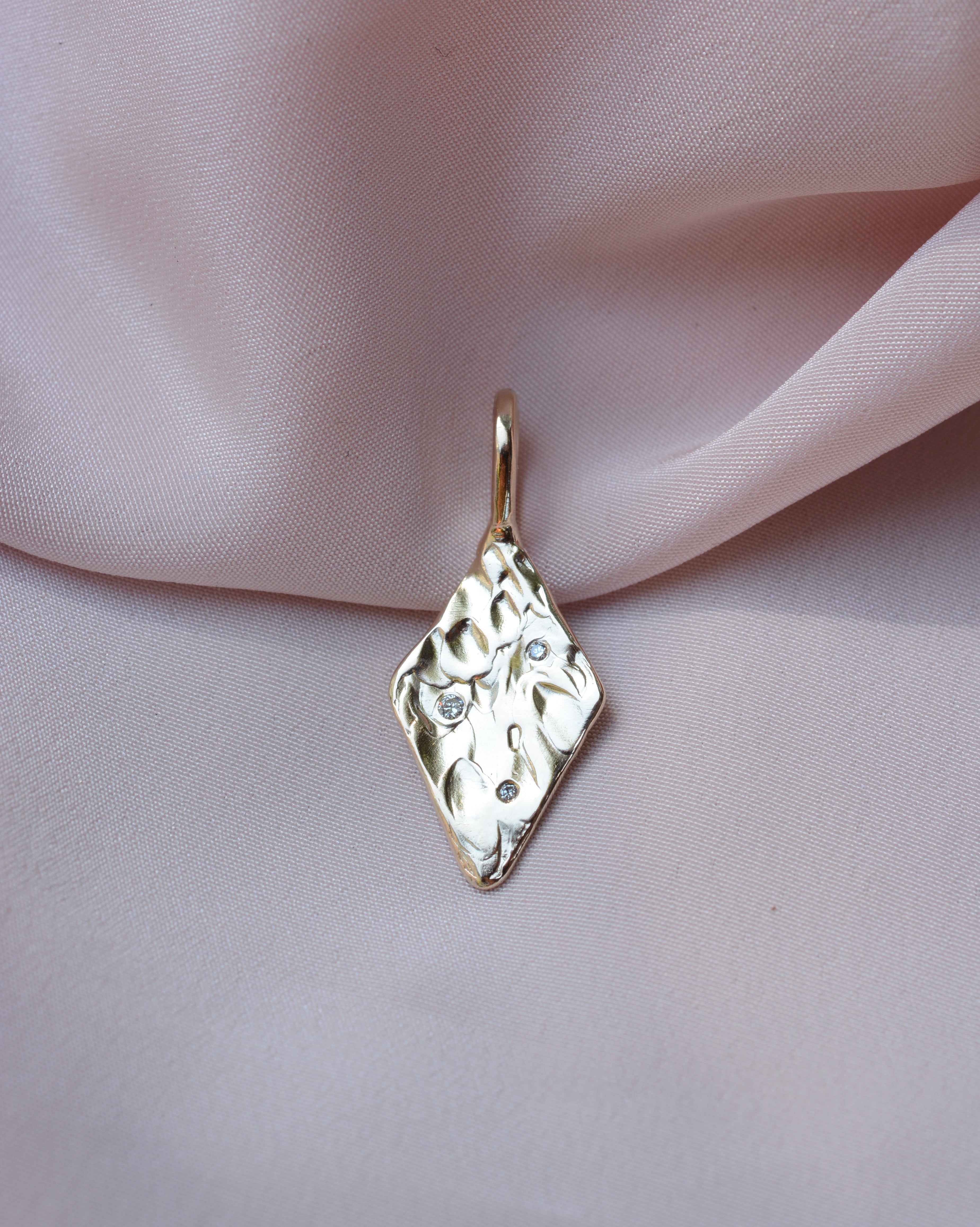 Diamond shaped pendant with organic texture and 3 flush set diamonds 