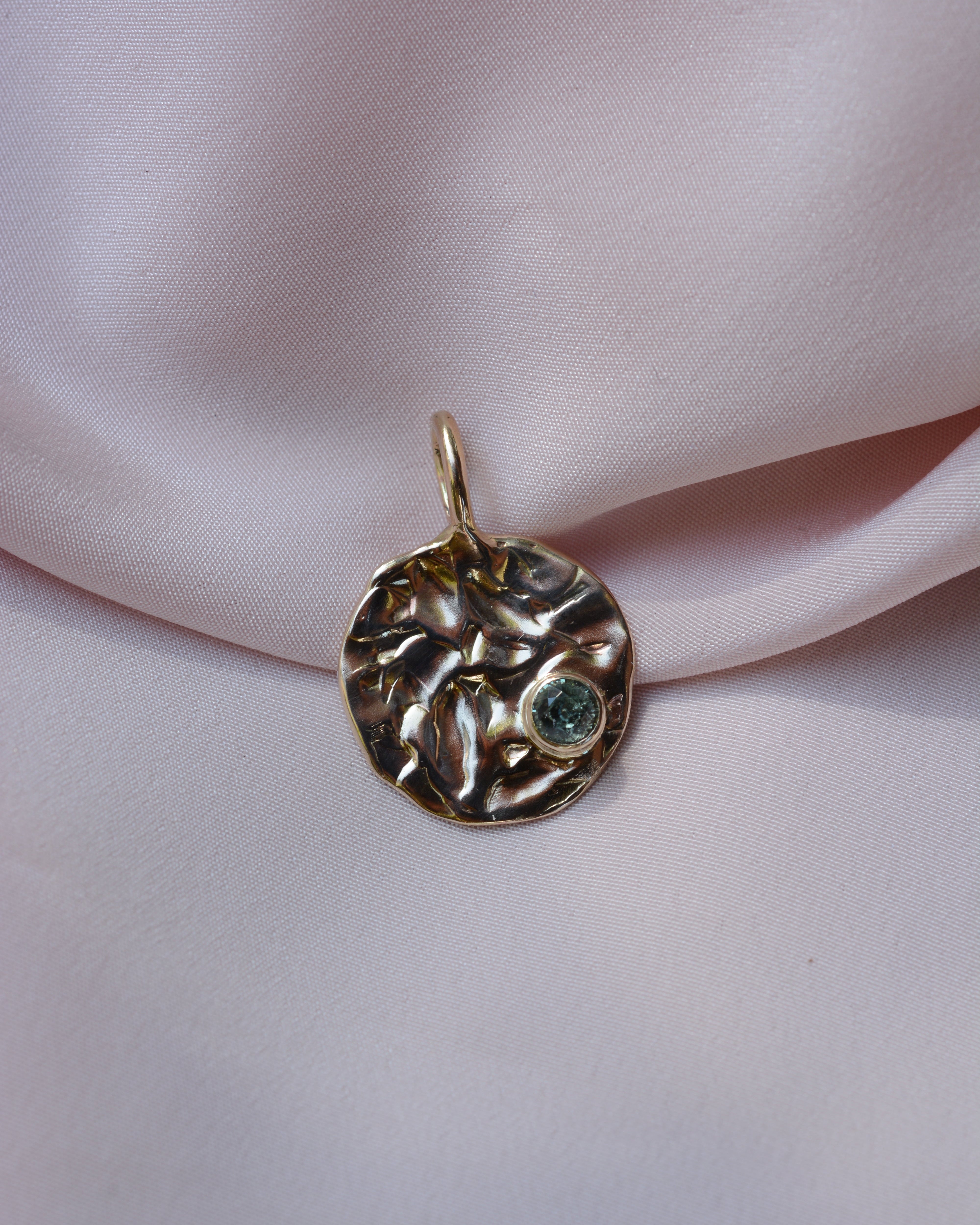 Round gold textured pendant with sapphire