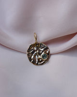 Round gold textured pendant with sapphire