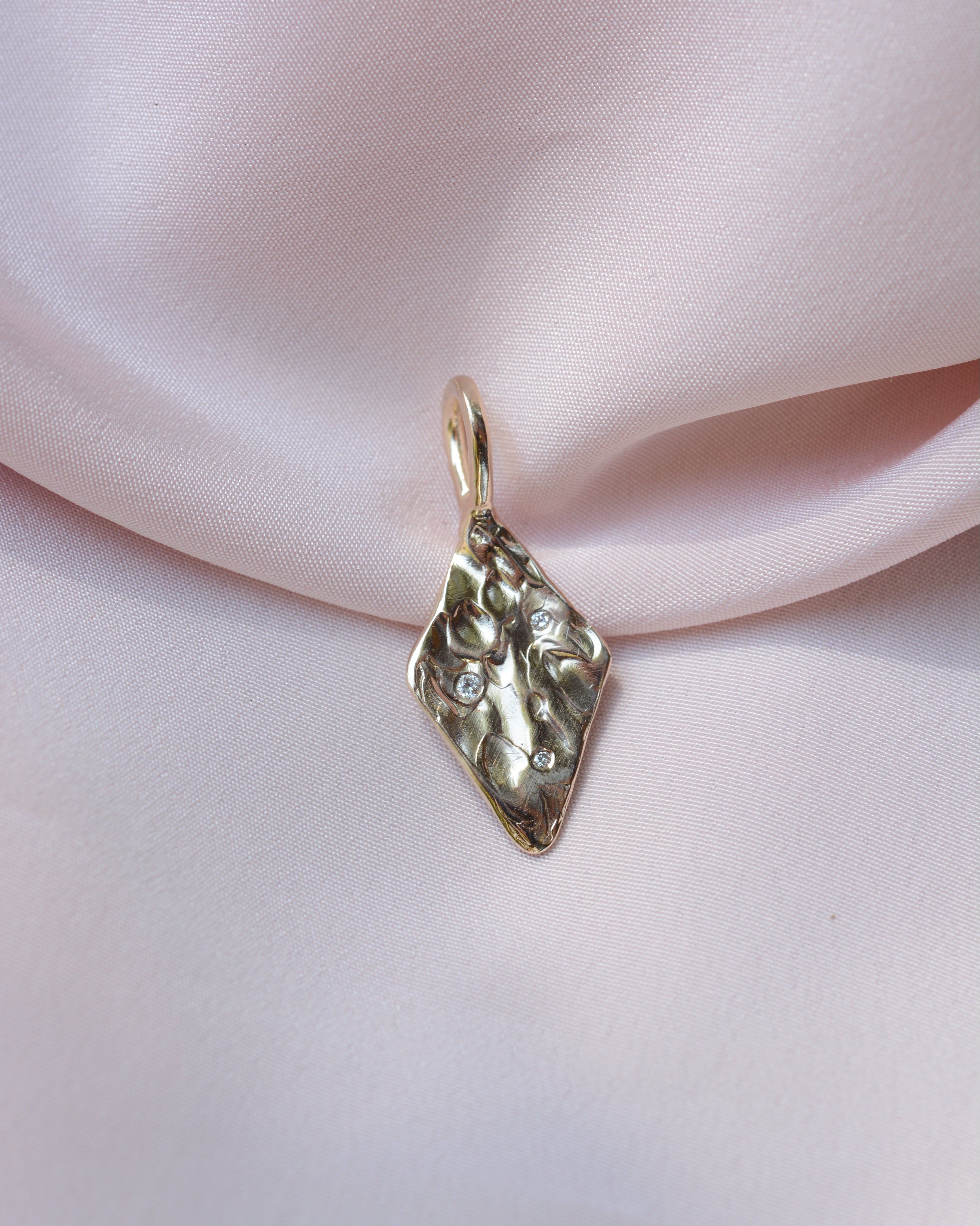 Diamond shaped pendant with organic texture and 3 flush set diamonds 