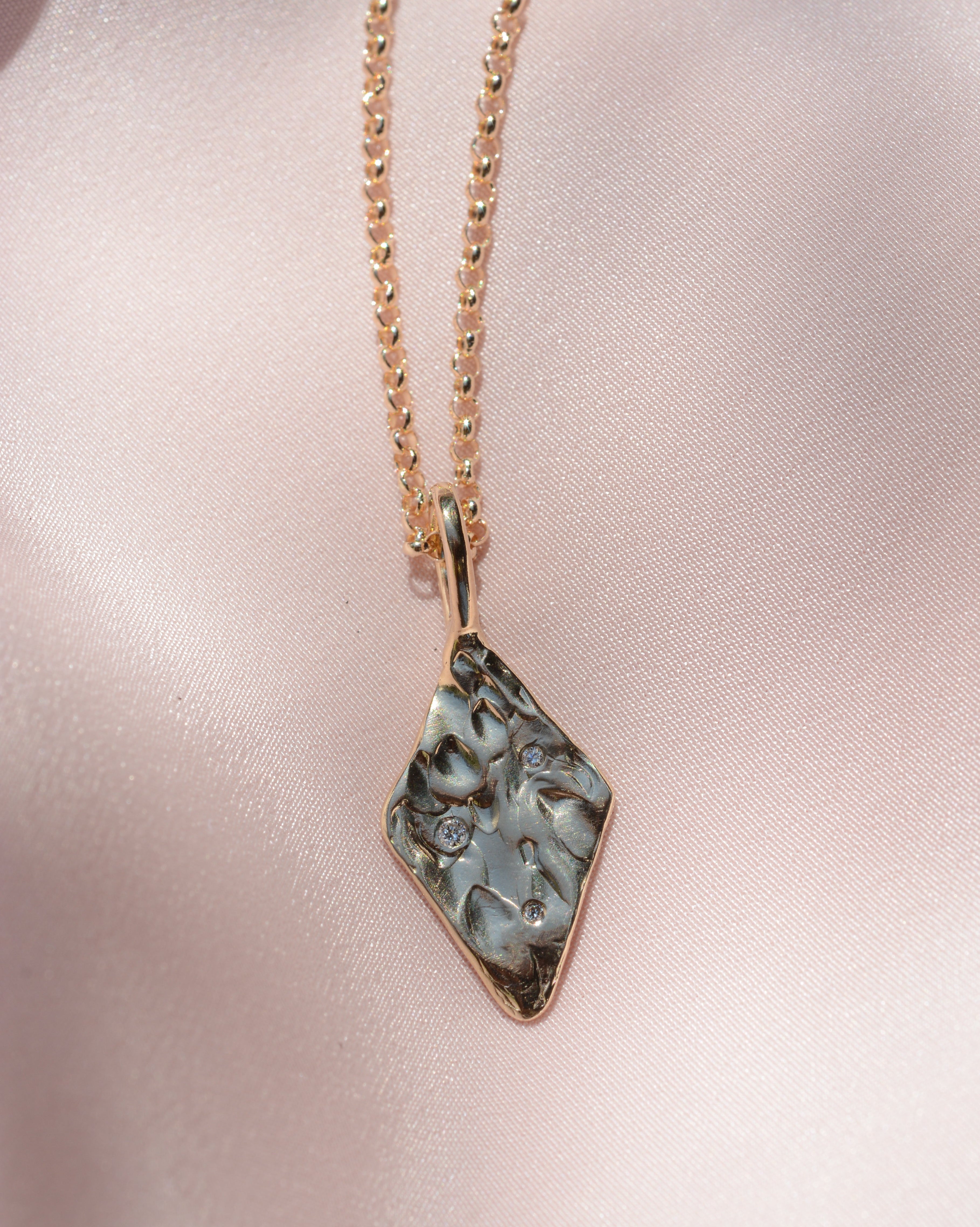 Diamond shaped pendant with organic texture and 3 lab grown flush set diamonds