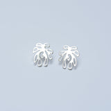 Pair of silver leaf-shaped earrings on a light blue background
