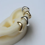 Bronze and silver ear cuff on a white background
