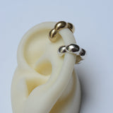 Silver and bronze bubble ear cuffs on a silicon ear