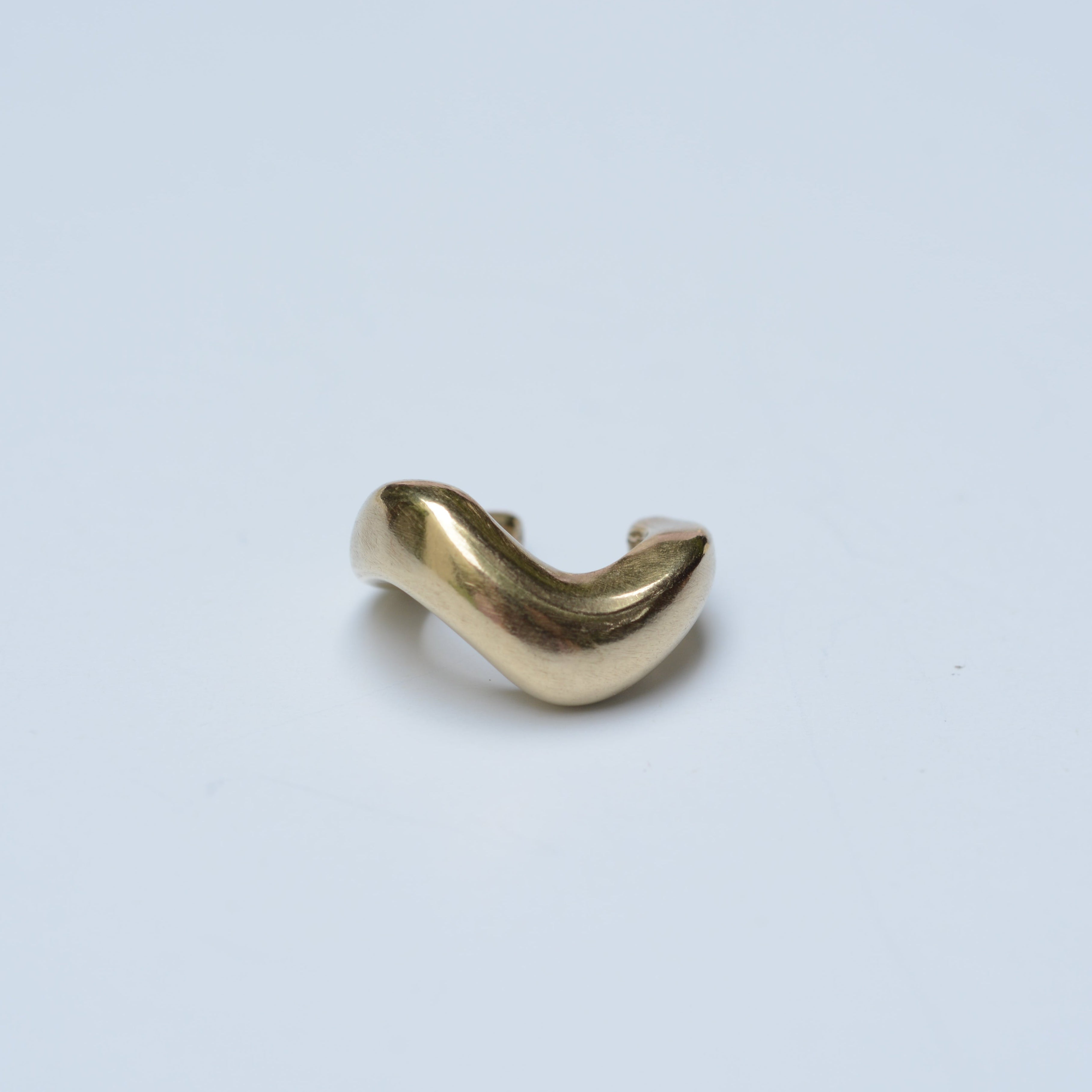Bronze wavy ear cuff on grey background