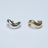 Wavy ear cuffs in silver and bronze on a white background