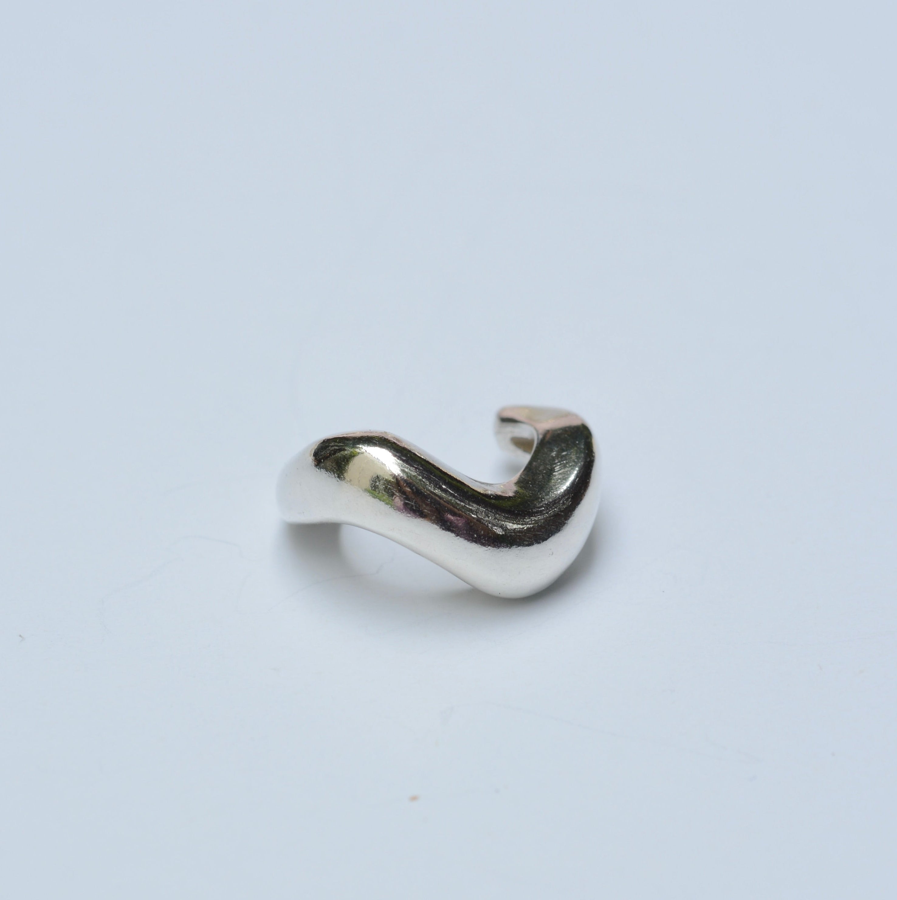 Silver wavy ear cuff on white background