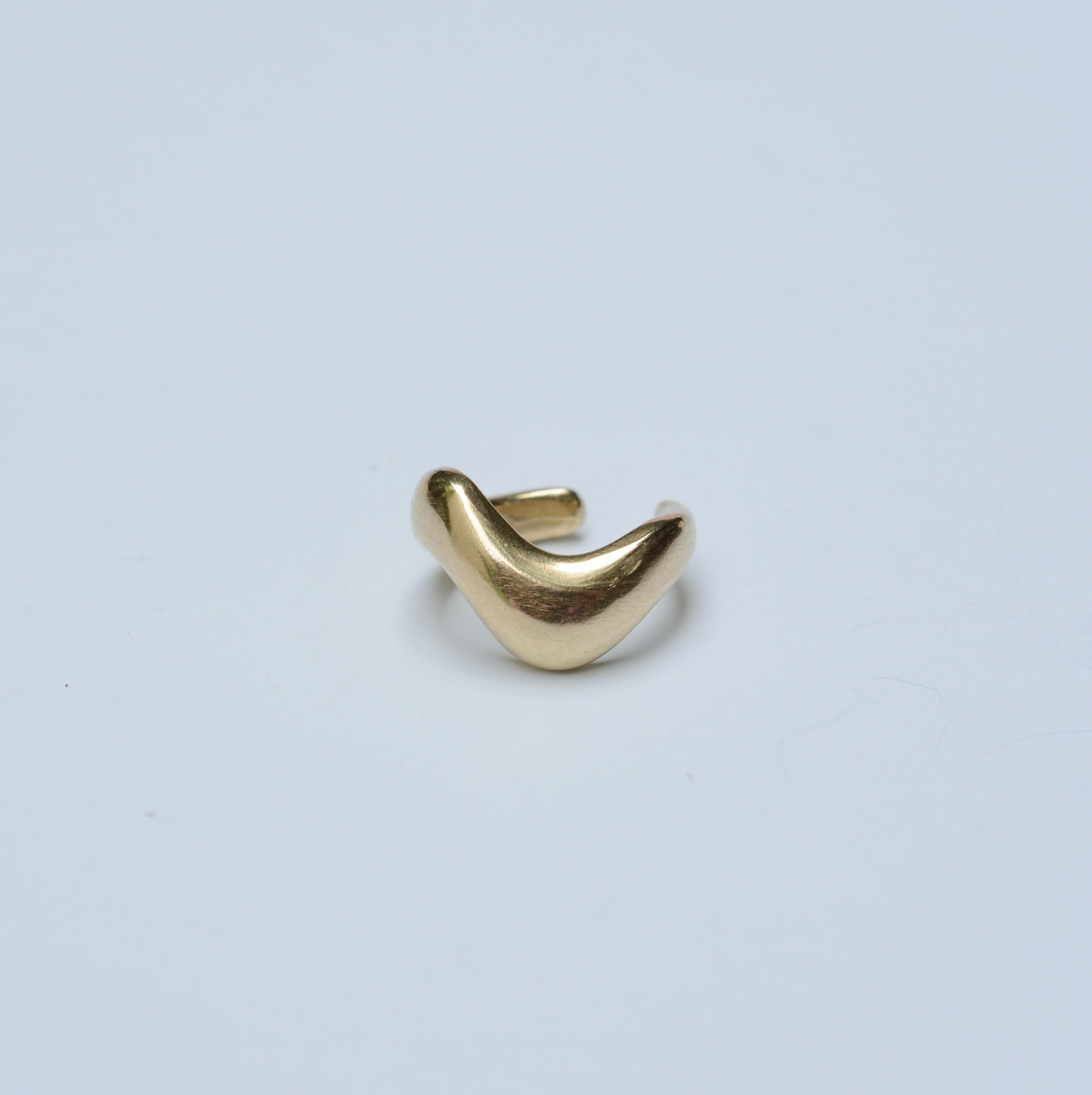 Bronze wavy ear cuff on a grey background