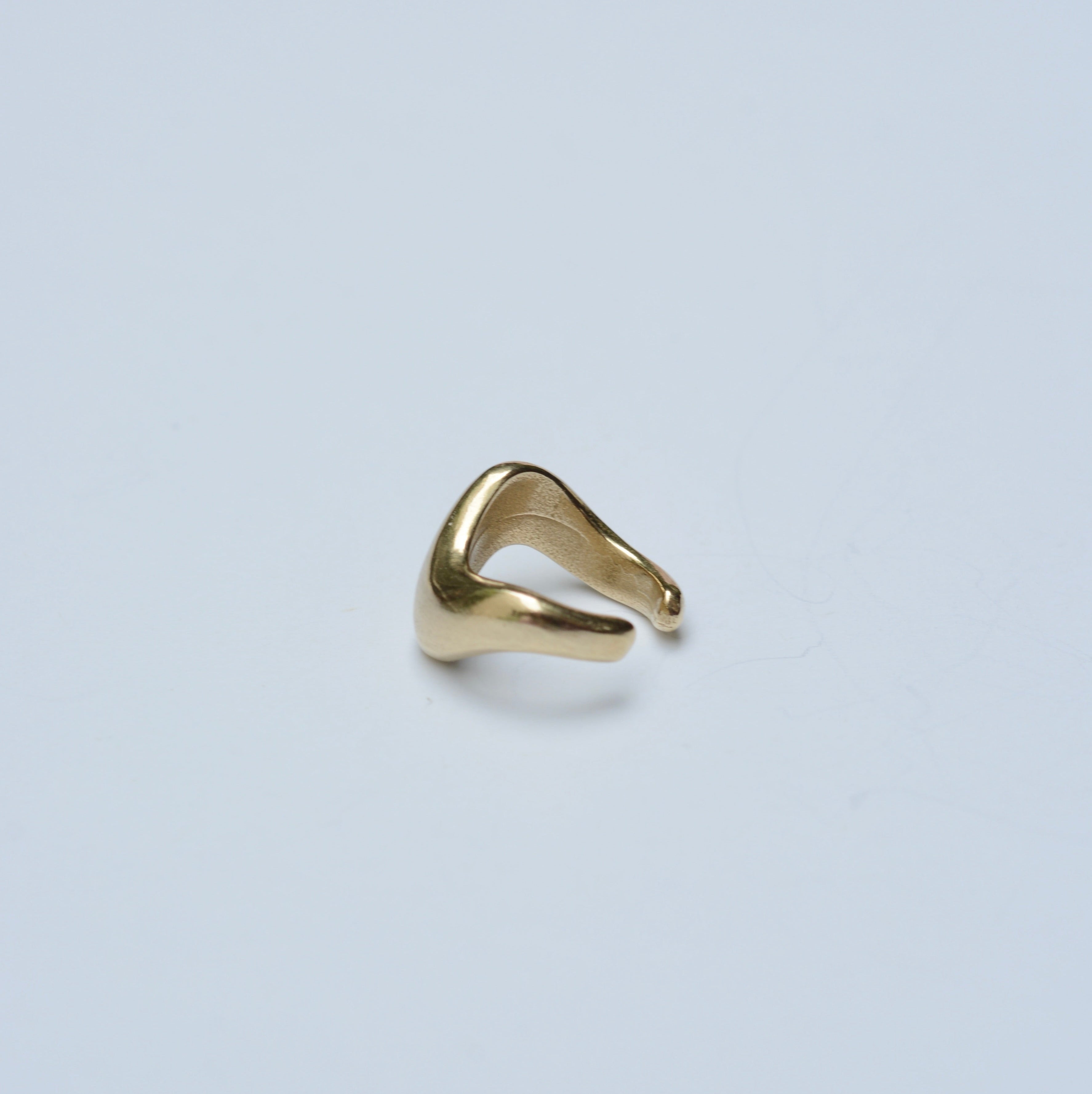 Bronze wavy ear cuff on grey background