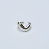 Silver wavy ear cuff on a grey background