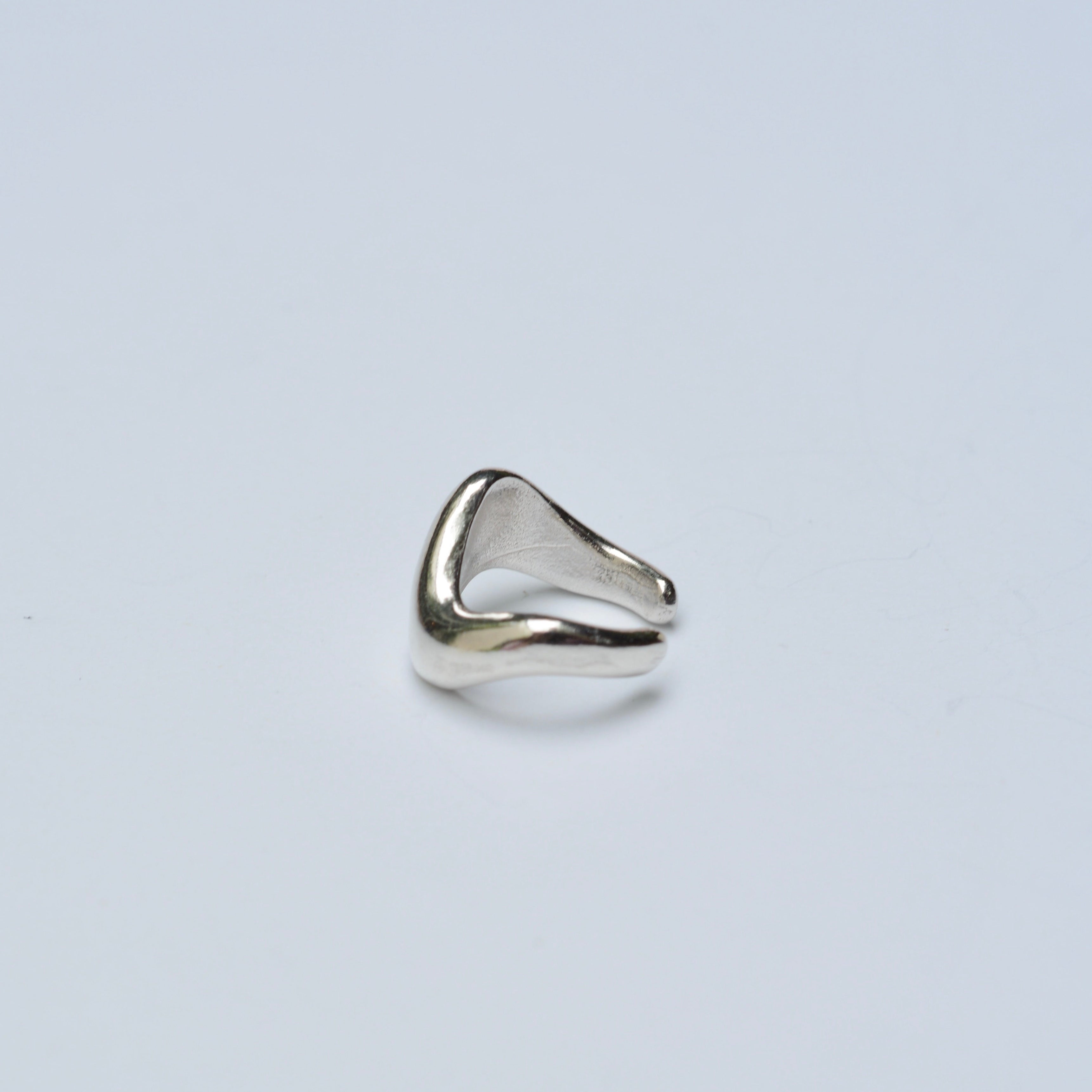 Silver ear cuff on grey background