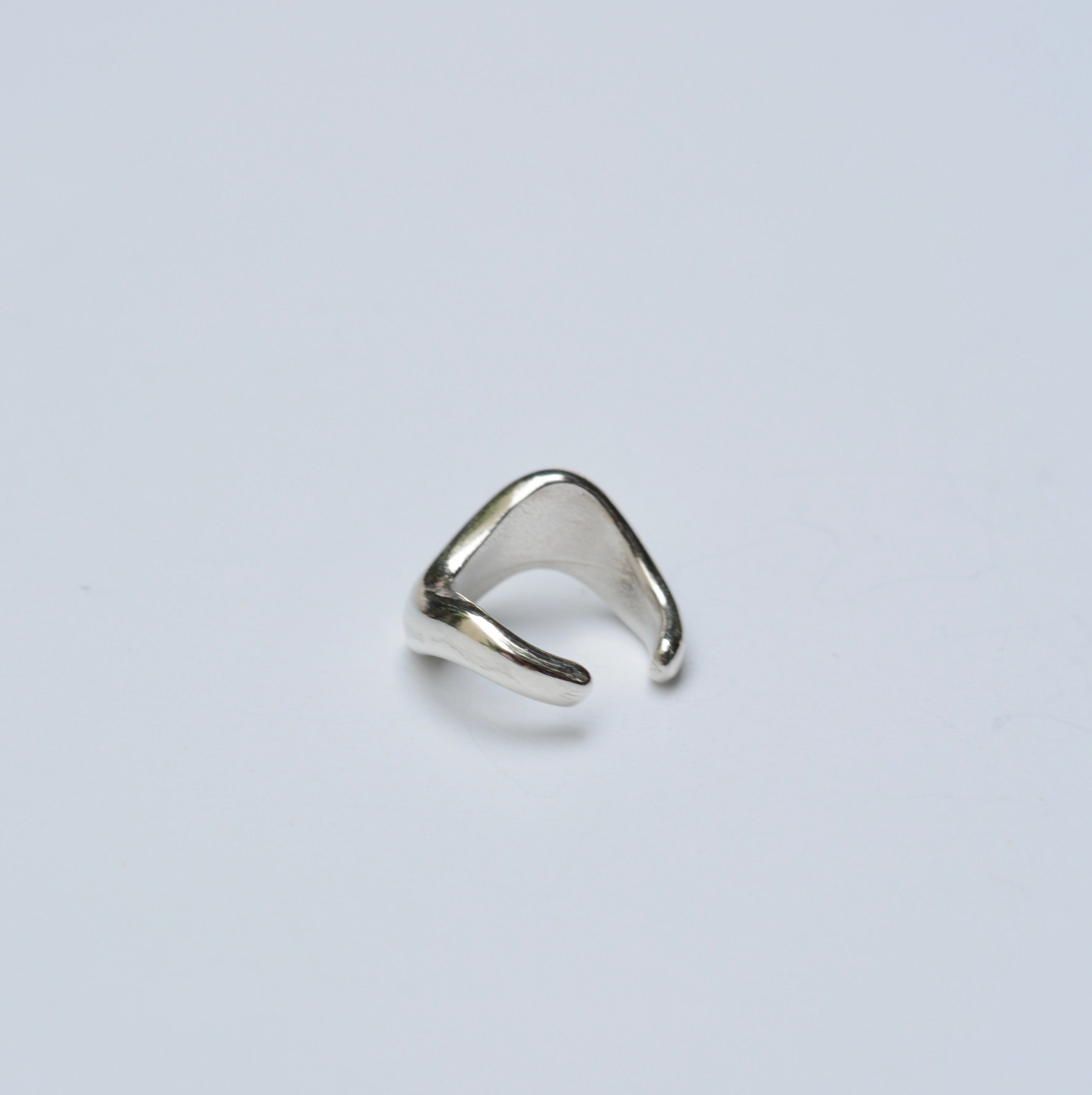 Silver organic ear cuff on white background