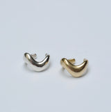 Bronze and silver wavy ear cuffs on a grey background