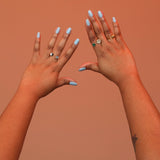 Two hands wearing an assortment of bronze rings with adjustable split shank designs