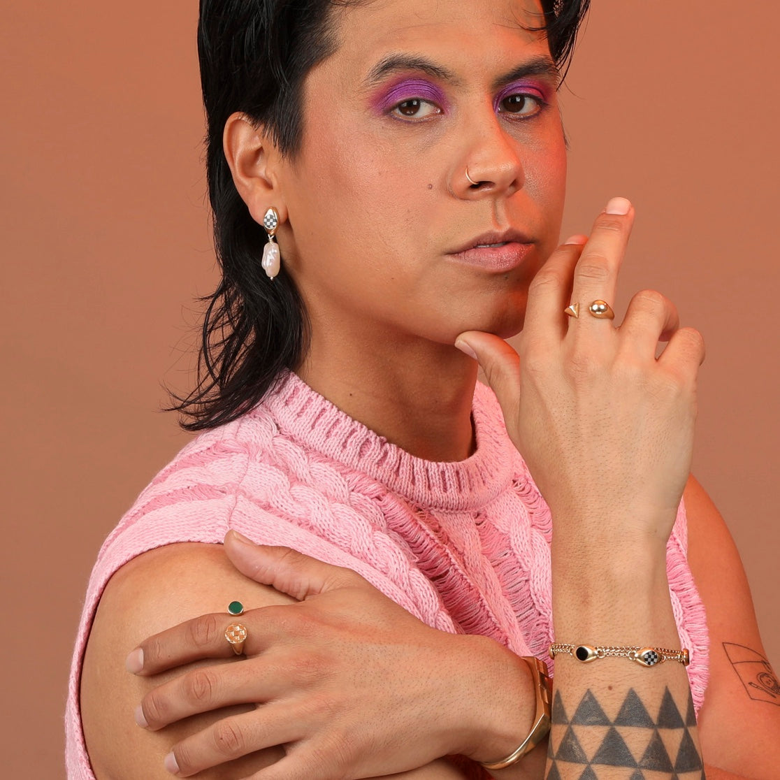 A person wearing an assortment of inlay and pearl jewelry